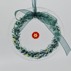 a glass ornament with a wreath on it