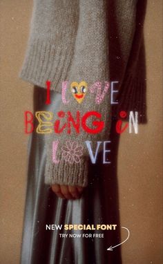 a woman's hand holding onto the back of her sweater that says i love being in love