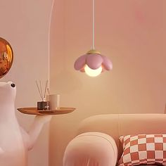 a living room with pink walls and an unusual light fixture hanging from the ceiling above it