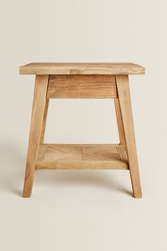 a small wooden stool sitting on top of a white floor