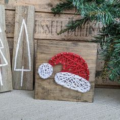 three wooden christmas signs with string work on them, one is red and the other is white