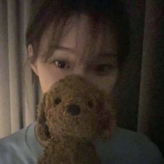 a woman holding a teddy bear in front of her face