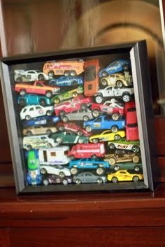 there are many toy cars in the shadow box