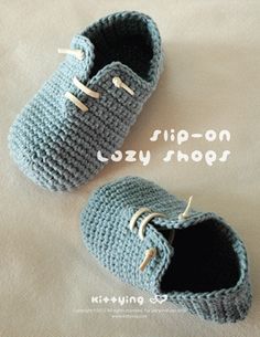 a pair of crocheted baby shoes sitting on top of a bed