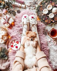 a person laying on top of a pink rug holding a small dog in their lap