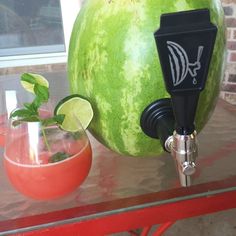 a watermelon sitting on top of a table next to a drink dispenser