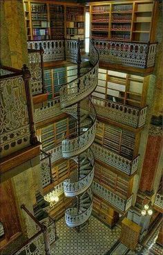 an aerial view of a spiral staircase in a library