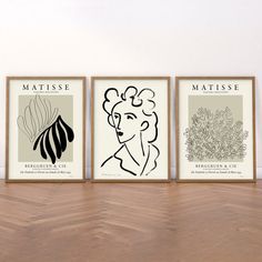 three framed art prints on a wooden floor