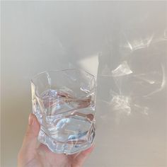 a hand holding a glass with water in it