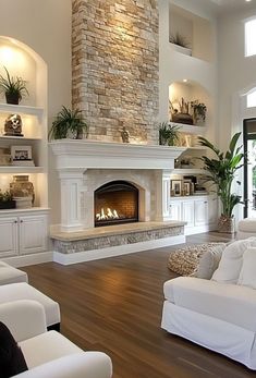 a living room with two white couches and a fireplace in the middle of it