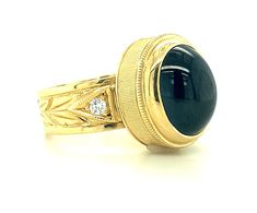 a gold ring with a black stone and diamonds