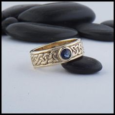 This 14K Yellow Gold Josephine Knot band features a bezel set Sapphire. The Josephine's knot is a traditional lover's knot. The strands intertwine continuously around the band to symbolize eternal love. This ring is a size 4 1/4 . Sizing is not available for this ring. Original designs © Stephen WalkerPlease call or email for more information800.488.6347 or service@walkermetalsmiths.com Josephine Knot, Eternal Love, Bezel Setting, Original Designs, Not Available, Knot, Gemstone Rings, Sapphire, Size 4