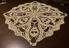 a crocheted doily sitting on top of a wooden table