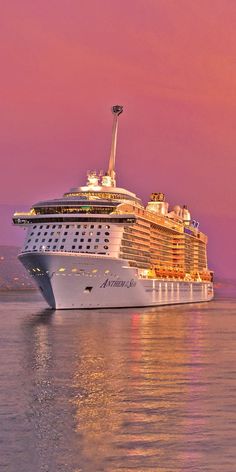 a cruise ship in the ocean at sunset