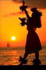 the silhouette of a woman dancing on the beach at sunset