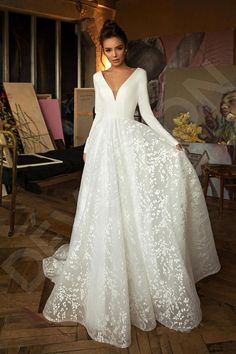 a woman in a white wedding dress posing for the camera with her hands on her hips