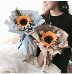 the woman is holding two bouquets of sunflowers