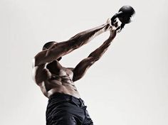 a shirtless man holding a football in the air with his right hand up to his head