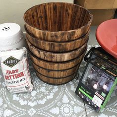 a wooden basket sitting next to a bucket and other items on top of a table