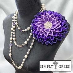 a purple flower and pearls necklace on a mannequin