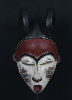 an old mask with horns and eyes is shown against a black background in this image