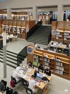 people are sitting at tables in the library