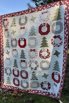 a quilted christmas tree is hanging on a clothes line in front of some trees