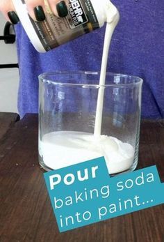 a person pouring milk into a glass on top of a wooden table with the words pour baking soda into paint