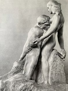 a black and white photo of two people touching each other's butts in front of a rock