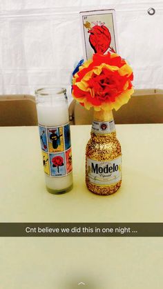 there is a vase with flowers in it next to a candle and a card on the table