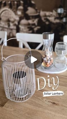 a white bird cage sitting on top of a wooden table