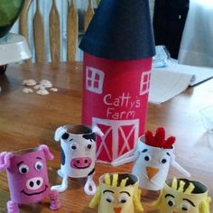 paper mache farm animals sitting on top of a wooden table