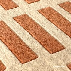 an orange and white rug with squares on it