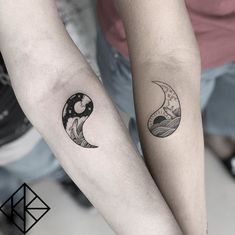 two people with matching tattoos on their arms, one is holding the other's arm