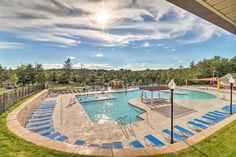 an outdoor swimming pool surrounded by lawn chairs