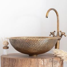 a large metal bowl sitting on top of a wooden table next to a white wall