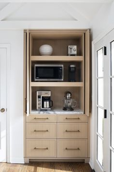 an open cabinet with microwave, toaster and coffee maker on top in a kitchen