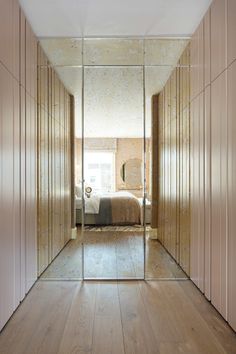 a bedroom with mirrored walls and wooden floors