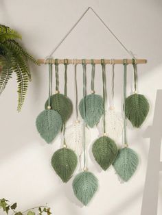 a green and white wall hanging with tassels