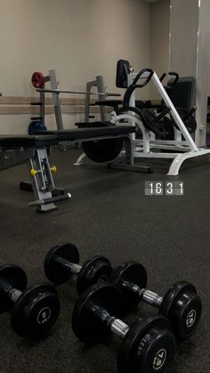 an empty gym with dumbbells and exercise equipment on the floor next to each other