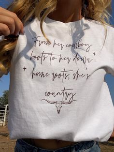 Brand new item!!  The perfect white t-shirt. A quote from a personal favorite song "from her cowboy boots to her down home roots, she's country" and a delicate outlines cow skull.  Made from 50% cotton and 50% polyester! Free shipping and limited quantity! If you would like this design on a different colored t-shirt message us and we are happy to customize it for you! White Graphic Tee For Western-themed Events, Casual White T-shirt For Western-themed Events, White Short Sleeve Tops For Country Events, Western White T-shirt For Country Events, Western Style White T-shirt For Country Events, White Letter Print T-shirt For Ranch, White Cotton Top For Country Events, White Cotton Tops For Country Events, Country Style White Graphic T-shirt