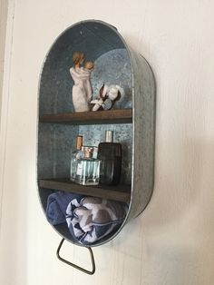 a mirror hanging on the side of a wall next to a shelf filled with bottles and towels