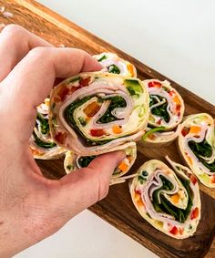 a person is holding some food on a wooden platter and it looks like they are going to eat something