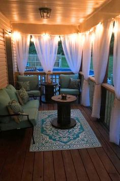 an outdoor living room with white curtains and lights