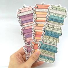 a person holding up some books with stickers in their hands on a white background