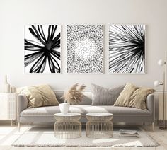 two black and white paintings on the wall above a couch in a modern living room