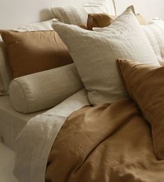 a bed with many pillows on top of it and a pillow case in the middle