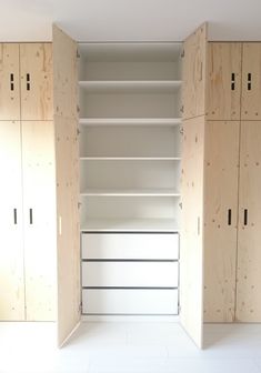 an empty closet with wooden shelves and white flooring in the middle, surrounded by plywood panels