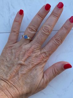 This is such a classy ring. A blue sapphire is simply set with four prongs and is accented by two dazzling diamonds. The sapphire is .75 ct with two accent diamonds (I1, H). The total gem weight is .85 ct. The ring is a size 6 1/2. This could easily be resized by your local jeweler. It is marked on the inside for 14K. It weighs 2.6 g. Condition Note- This has been previously sized and has a line in the gold on the back of the band. Priced accordingly. AJJ Classic Three Stone Jewelry With Lab-created Sapphire, Three Stone Ring With Lab-created Sapphire For Gift, Blue Sapphire Three-stone Birthstone Ring, Silver Birthstone Ring With Lab-created Sapphire And Accent Stones, 14k Gold Three-stone Sapphire Ring As A Gift, Sapphire Diamond Engagement, Diamond Sapphire Engagement Ring, Hand Ring, Platinum Diamond Engagement Rings