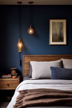 a bed in a bedroom with blue walls and two lamps hanging from the headboard